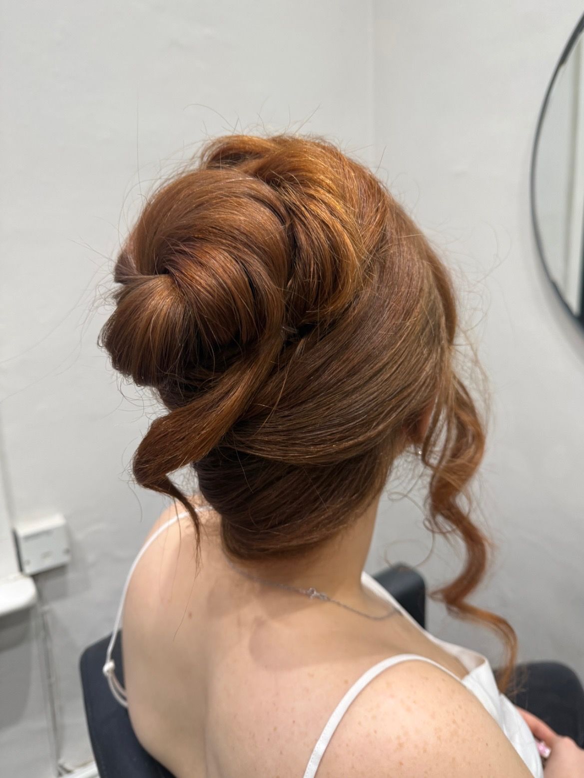 Voluminous copper updo with soft twists, seen from behind