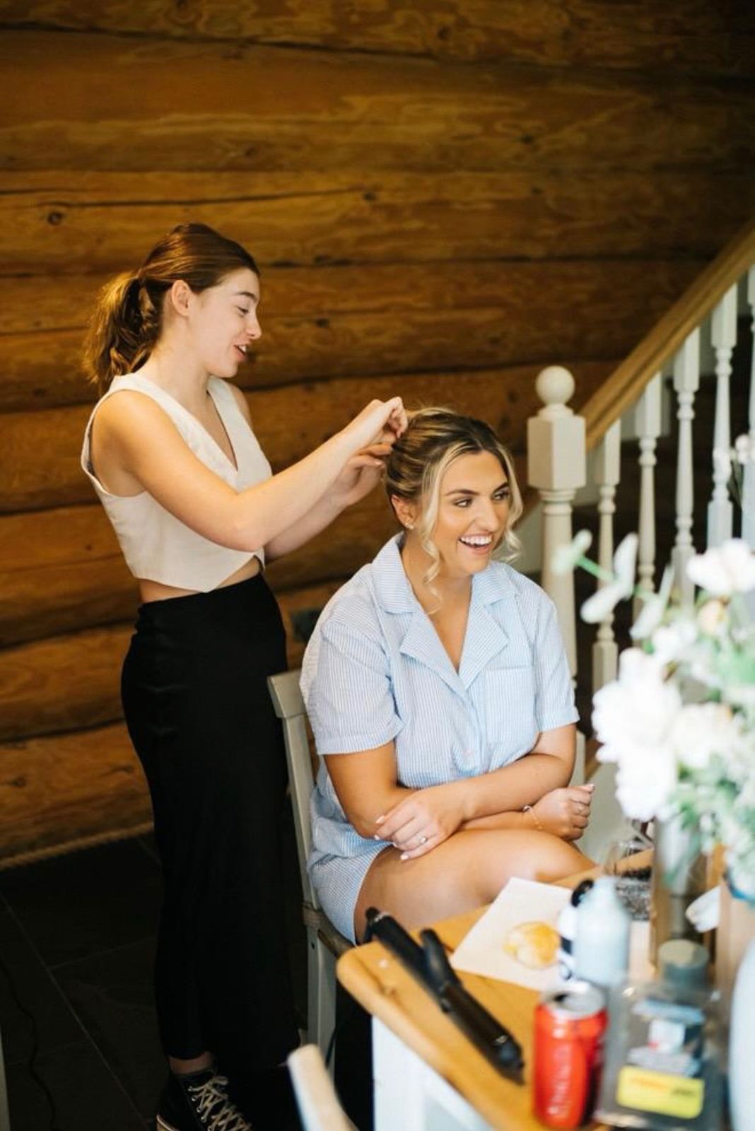 Mya Irvine pinning a smiling client's hair on a wedding morning
