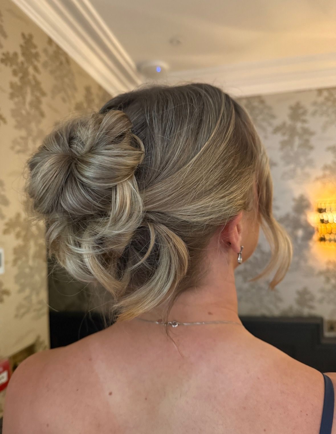 Textured low updo in blonde tones, seen from behind